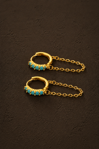 Gouden Amalfi glow oorbellen van Fencyjewels met turquoise details en een subtiel hangend kettinkje.
