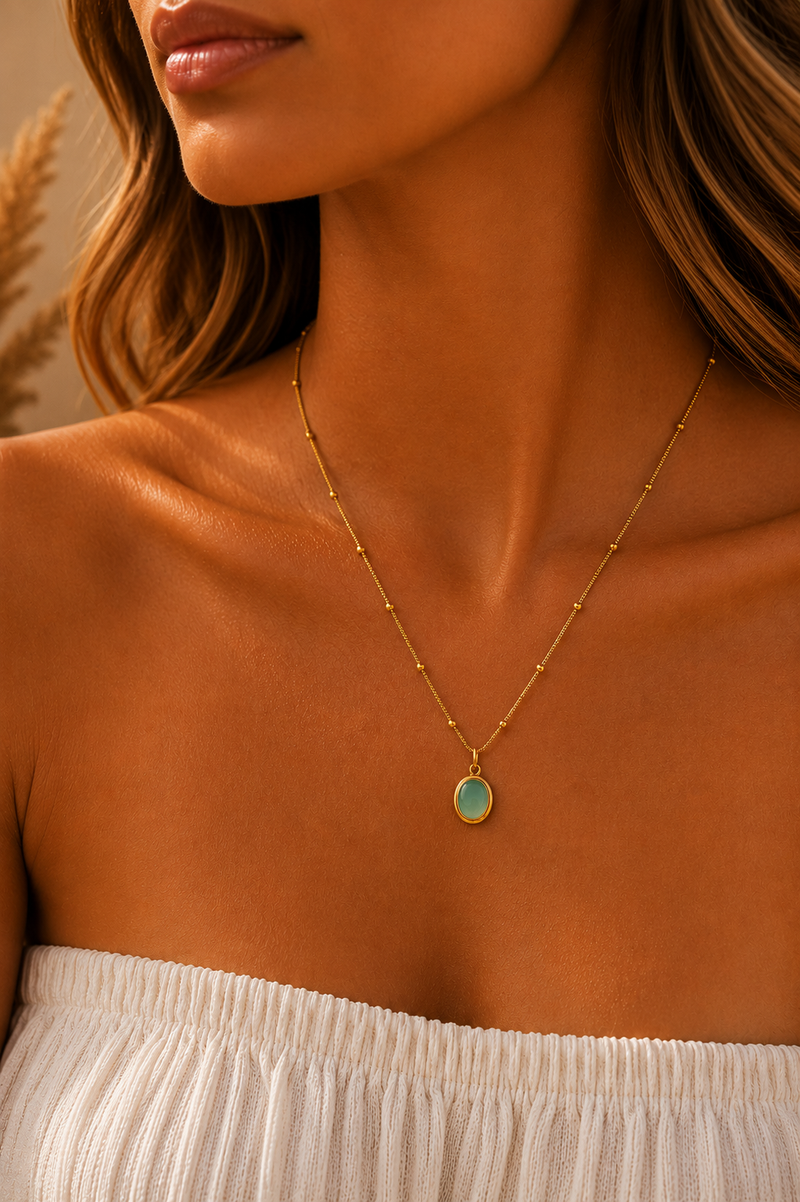 Model draagt de gouden Amalfi ketting van Fencyjewels met een subtiele turquoise hanger.