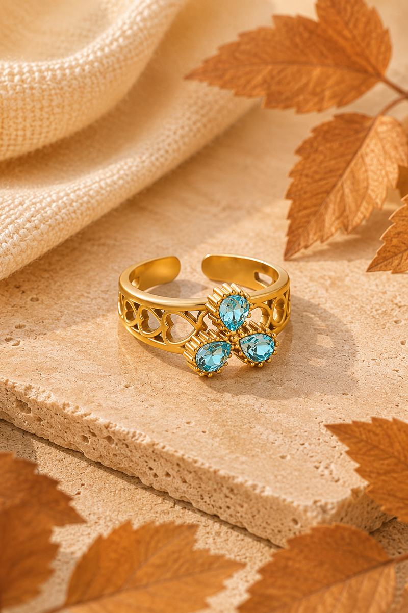 Gouden Bella blue ring van Fencyjewels met helderblauwe stenen in een speels bloemdesign.