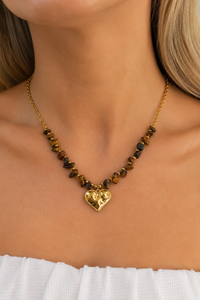 Model draagt de gouden Brown heart ketting van Fencyjewels met bruine stenen en een goudkleurige hartvormige hanger.