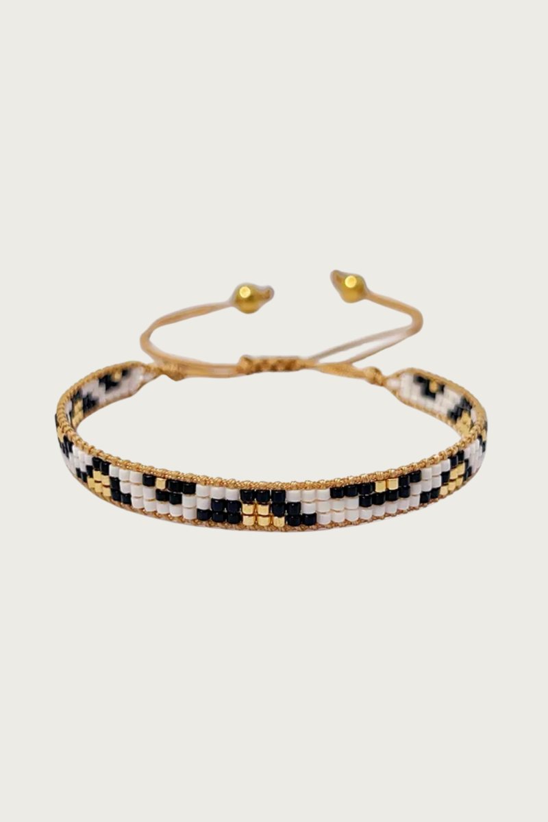 Ibiza armband van Fencyjewels – handgemaakte kralenarmband met zwart, wit en goud patroon, verstelbare sluiting en gouden details, stijlvolle boho armband voor dames.