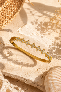 Gouden Flower bangle van Fencyjewels met verfijnde bloemetjes en subtiele sprankelende steentjes.