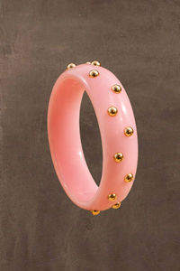 Candy bangle van Fencyjewels in zachtroze met speelse goudkleurige bolletjes rondom de armband.