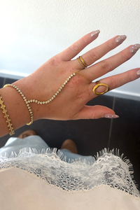 Gouden Sparkle handchain van Fencyjewels gedragen om de hand met een verfijnd kettinkje tussen pols en vinger.