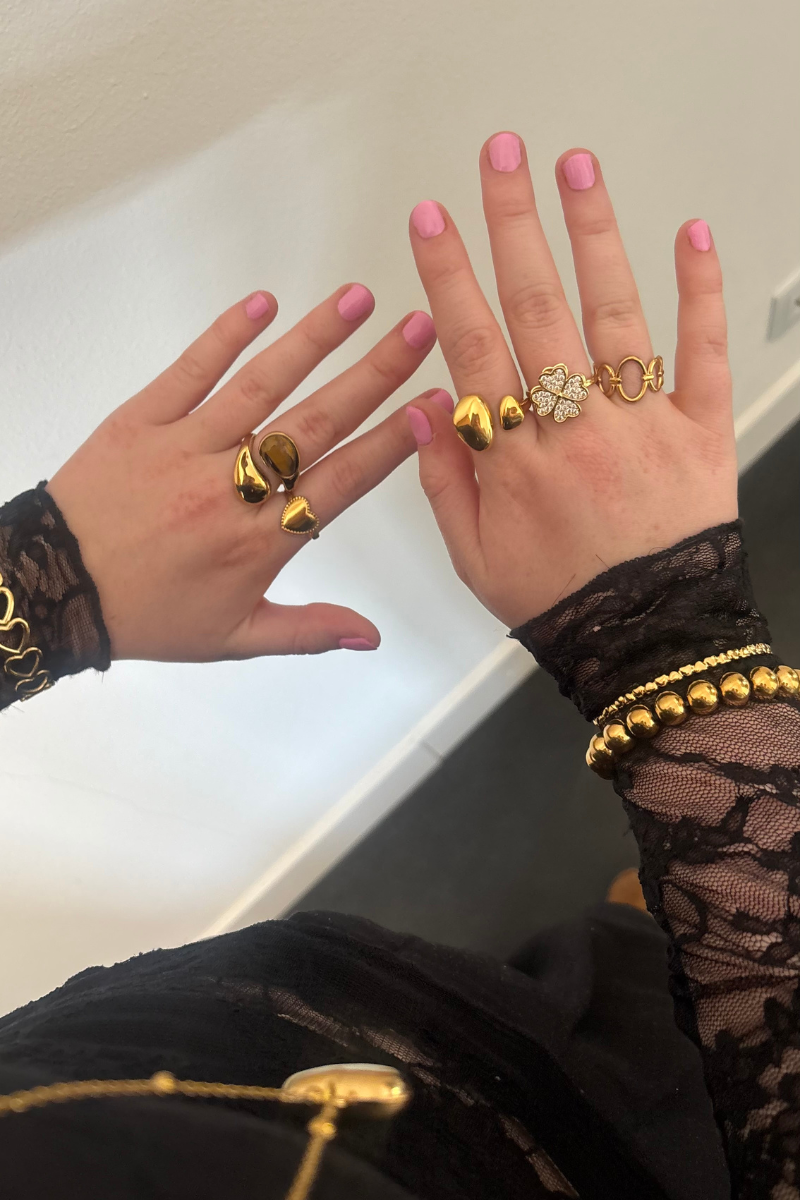 Brown glow ring van Fencyjewels gedragen om de hand. Gouden ring met bruine steen, stijlvol te combineren met andere sieraden voor een trendy look.