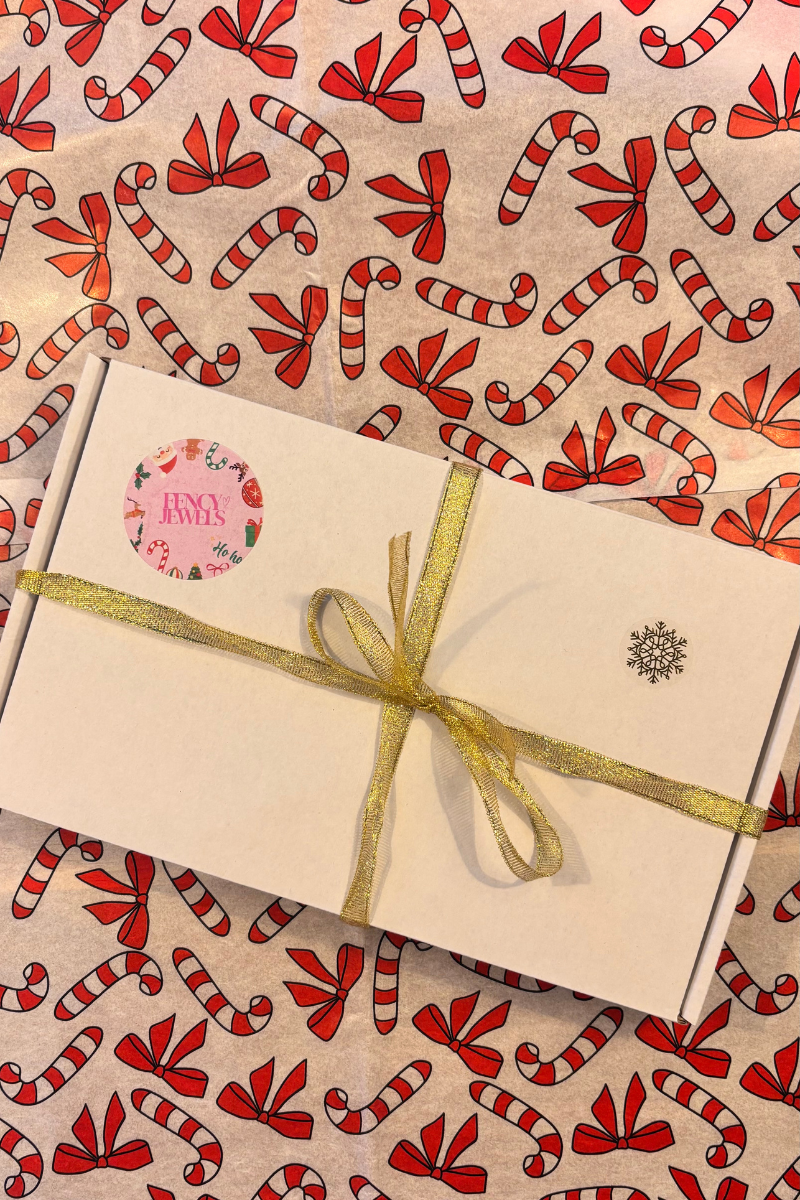 Luxe Fencyjewels cadeauverpakking met gouden lint — perfect kerstcadeau voor haar. Stijlvolle sieraden uit Nederland, feestelijk verpakt voor kerst en speciale gelegenheden.