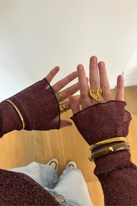 Foto van de gouden love ring gedragen aan de hand, minimalistische ringstack.