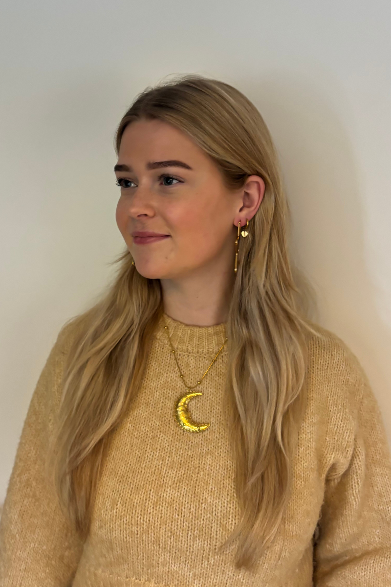 Gouden maan ketting gedragen op een mooie trui voor een layered look.