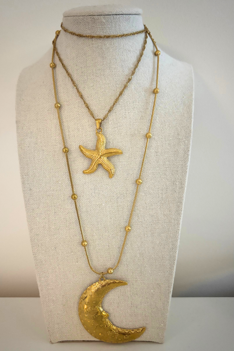 Gouden maan ketting gedragen op een mooie display voor een layered look.