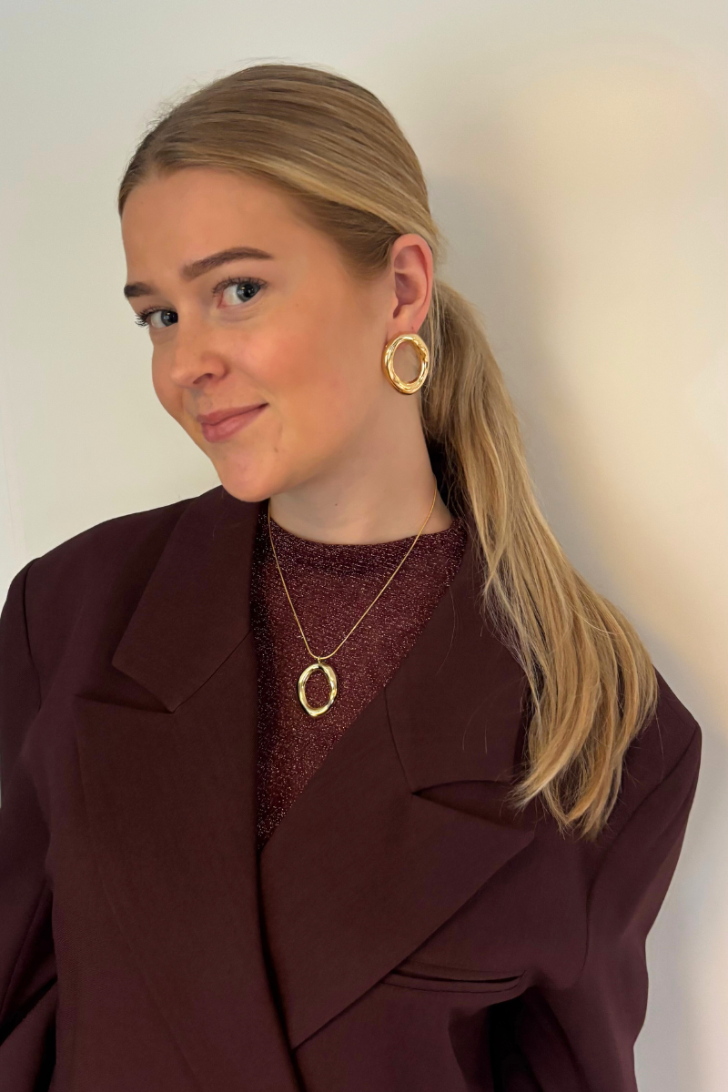 Sfeerfoto van de gouden round circle oorbellen gedragen in het oor, een tijdloze toevoeging aan je ear-party.