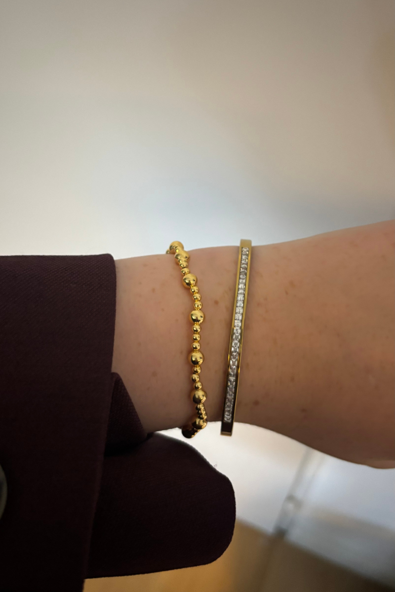 Lifestyle foto van de gouden stretch balls armband gedragen bij een casual outfit.