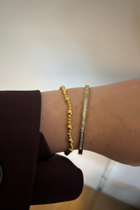 Lifestyle foto van de gouden stretch balls armband gedragen bij een casual outfit.