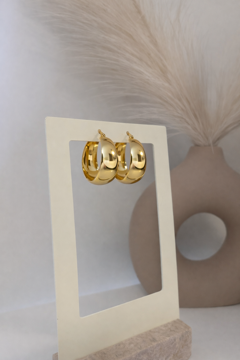 Glow hoops van Fencyjewels in goudkleur op display. Chunky oorbellen van stainless steel, waterproof en perfect voor een trendy en opvallende look.