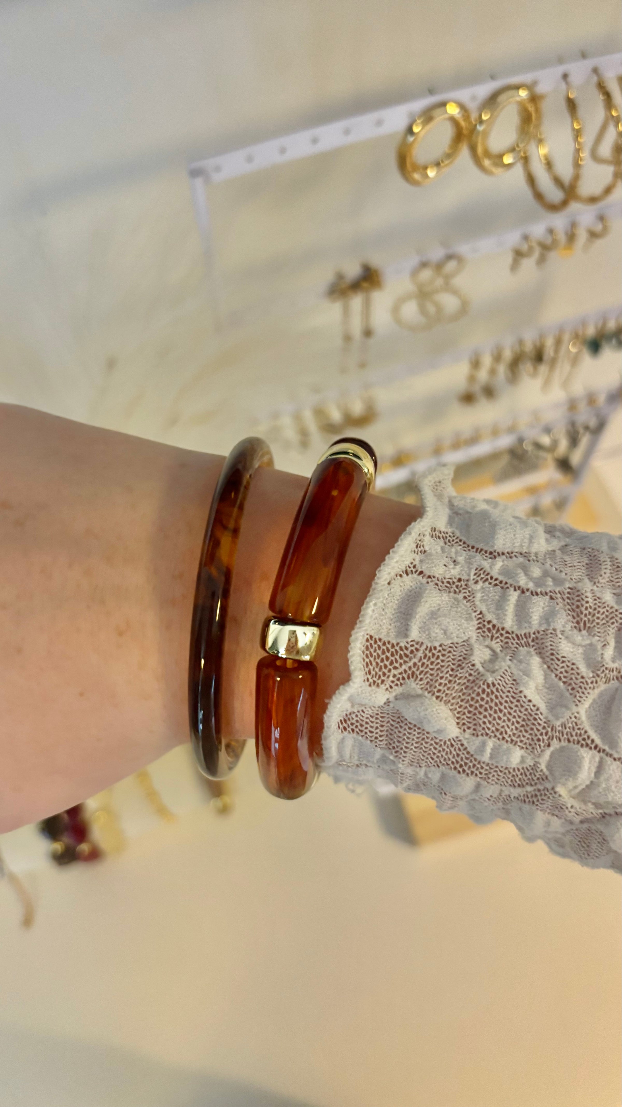 Goudbruine bangle armband van Fencyjewels gedragen om de pols. Glanzende armband met warme amber tinten en luxe uitstraling, perfect te combineren met andere sieraden.
