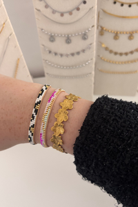 Fencyjewels gouden bloemenarmband gecombineerd met kleurrijke Ibiza armbanden met kralen – trendy dames sieraden in bohemian stijl, perfect voor elke zomerse look.