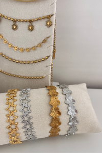 Fencyjewels armbanden en kettingen – gouden en zilveren sieraden met bloemen-, hart- en stervormige schakels. Luxe en trendy collectie damesarmbanden en halskettingen gepresenteerd op fluwelen display.