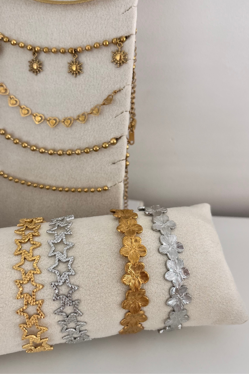 Fencyjewels armbanden en kettingen – gouden en zilveren sieraden met bloemen-, hart- en stervormige schakels. Luxe en trendy collectie damesarmbanden en halskettingen gepresenteerd op fluwelen display.