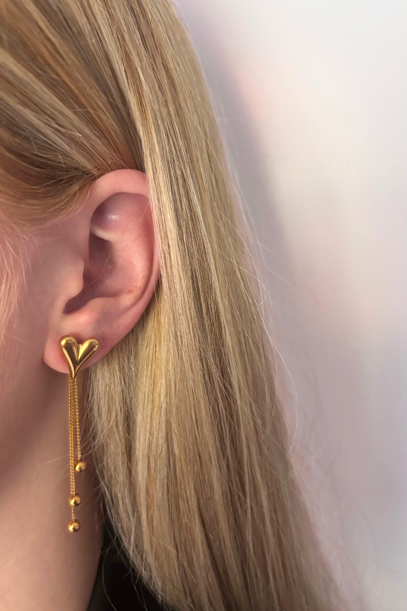 Fencyjewels gouden hart oorbel met dubbele ketting en bolletjes. Elegant gold plated design dat liefde en stijl uitstraalt – perfecte oorbel voor dames.