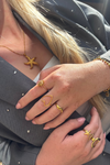 Fencyjewels gouden sieraden set met zeester ketting en verschillende ringen. Hand met stijlvolle gold plated ringen in hart-, golf- en zonvorm voor een chique zomerse look.