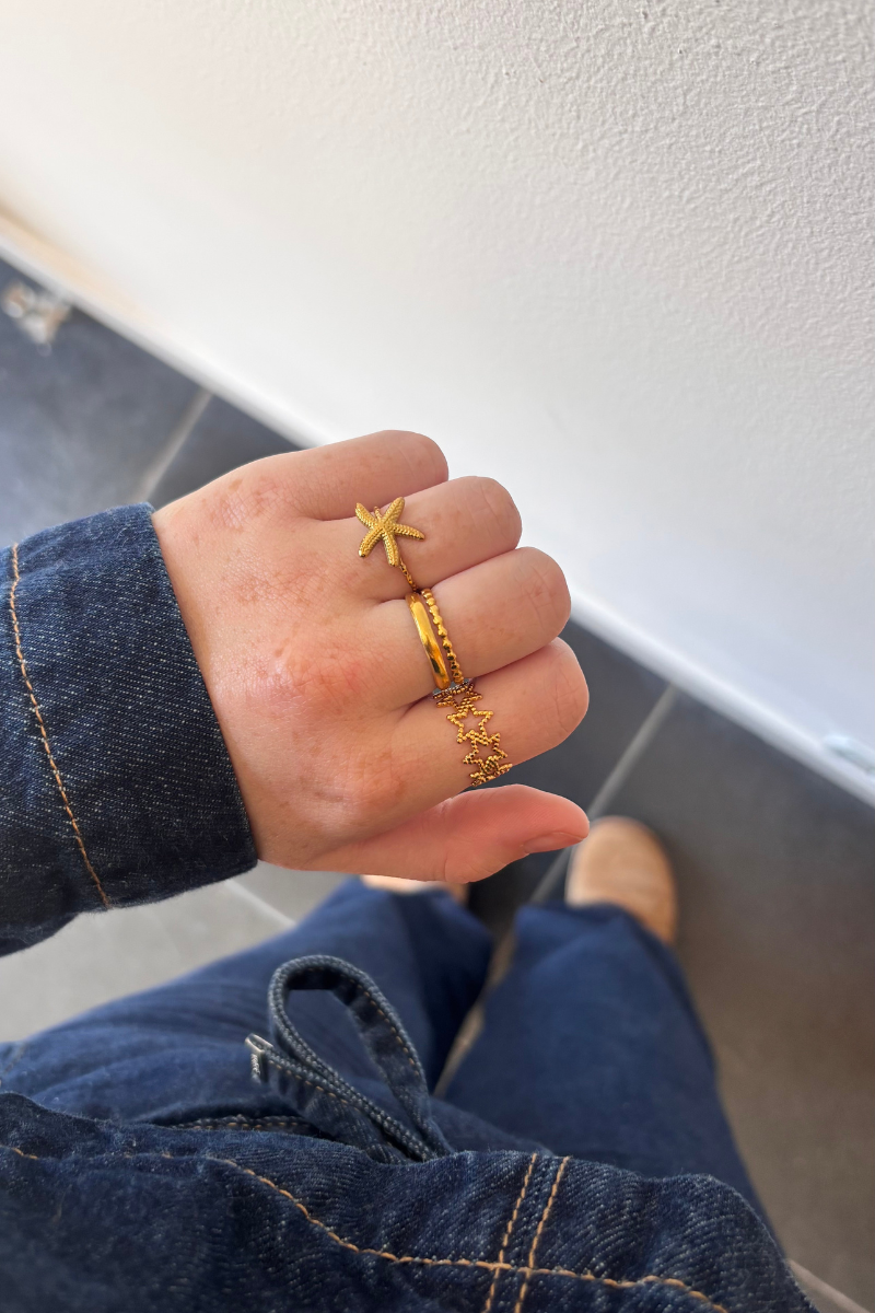 Fencyjewels gouden ringen – stijlvolle combinatie van een zeester ring, gladde gold plated ring en sterren ring. Trendy zomerse sieraden voor dames, ideaal voor een elegante look.