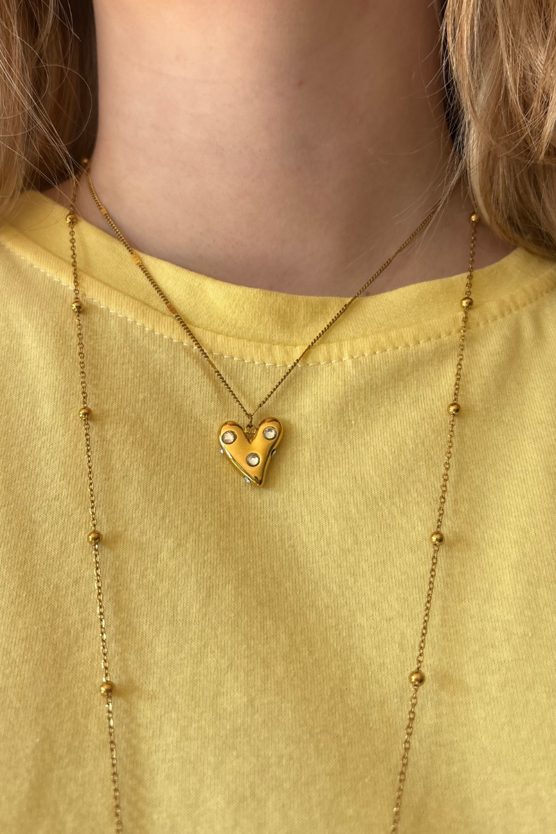 Heart pearl ketting van Fencyjewels close-up gedragen om de hals. Gouden ketting met hartje en pareldetails voor een zachte en vrouwelijke look.