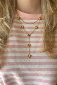 Layered love ketting van Fencyjewels close-up gedragen om de hals. Gouden ketting met meerdere laagjes en hartjes voor een speelse en stijlvolle uitstraling.