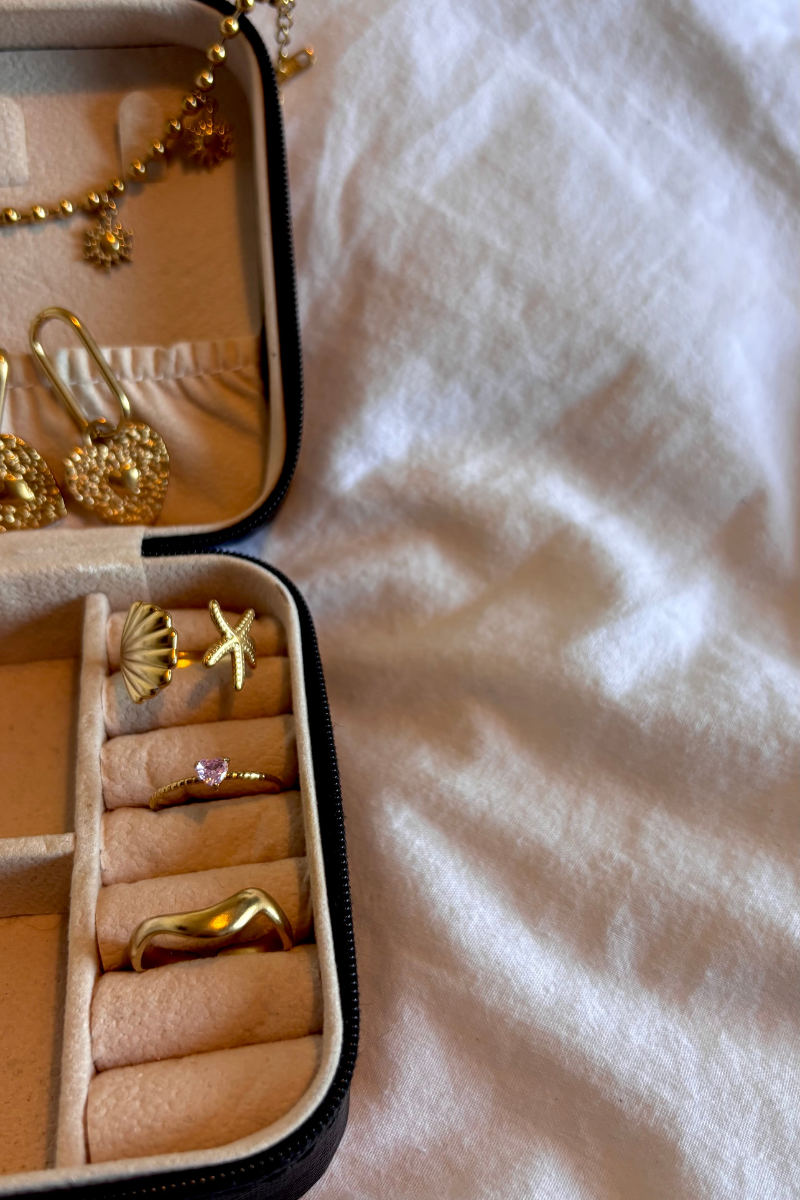 Luxe sieradendoos met gouden ringen en oorbellen van Fencyjewels, waaronder een zeester ring, schelp oorbel en hartvormige oorbellen. Perfecte flatlay voor stijlvolle gouden accessoires.
