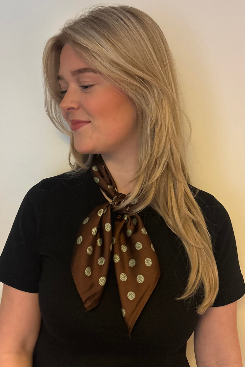 Sjaal bruin met stippen van Fencyjewels stijlvol gedragen door model. Elegante en tijdloze accessoire met zachte stof en moderne uitstraling.