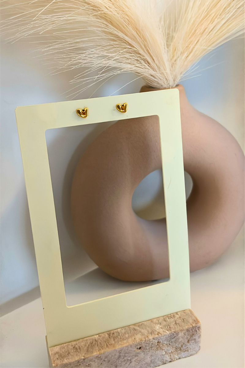 Small heart studs van Fencyjewels in goudkleur op display. Minimalistische oorbellen met klein hartje, gemaakt van stainless steel en perfect voor dagelijks gebruik.