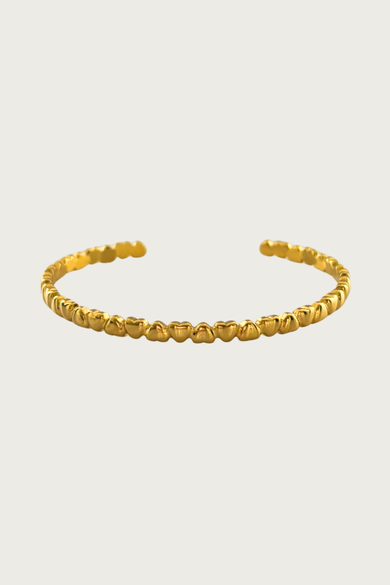 Small hearts bangle van Fencyjewels met kleine hartjes in goudkleur. Elegante armband van stainless steel, waterproof en perfect voor een vrouwelijke look.