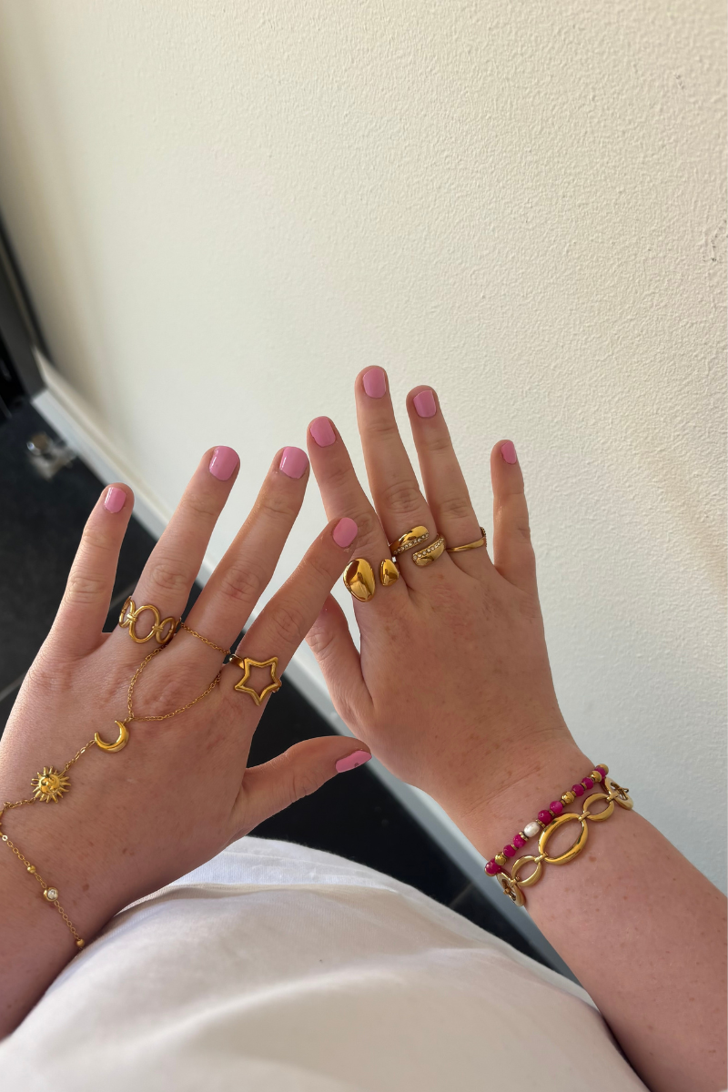 Star ring van Fencyjewels gedragen om de hand. Gouden ring met ster detail, stijlvol te combineren met andere ringen.